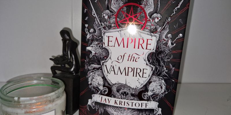 A book (Empire of the Vampire by Jay Kristoff) on a white shelf with a candle from Istoria